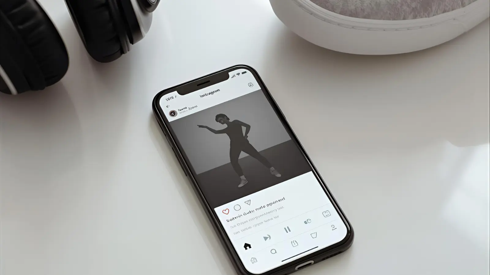 Phone with a dance Reel open, headphones and sneaker nearby.